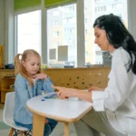 Speech therapist working with a young child during a language assessment.
