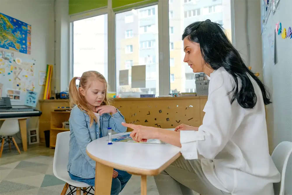 Speech therapist working with a young child during a language assessment.